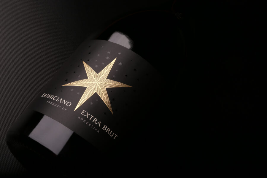Tres botellas de Bodega Domiciano: Estelar Blanco Dulce, Cosecha Nocturna Malbec y Extra Brut sobre una mesa de madera para el Mundial 2026